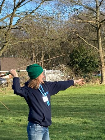 Lady in a hat throwing a javelin