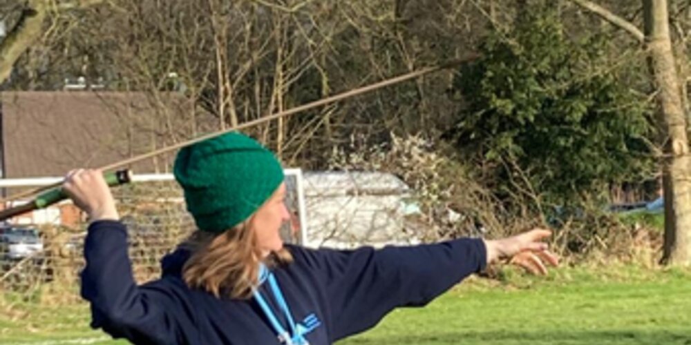 Lady in a hat throwing a javelin
